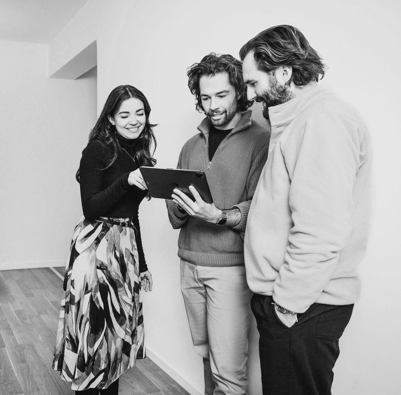 Three Creatica colleagues collaborating around a tablet in the Munich office